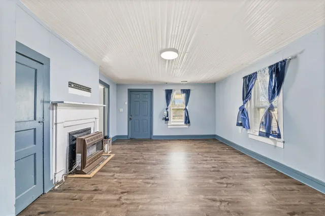 a view of an empty room with a fireplace and a window