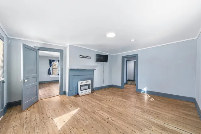 a view of an empty room with a fireplace and a window