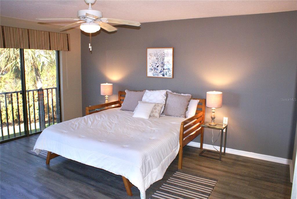 601 Shreve Street, Unit 15B Punta Gorda, FL 33950 - Photo 14 of 29 a bedroom with a bed and a lamp with wooden floor