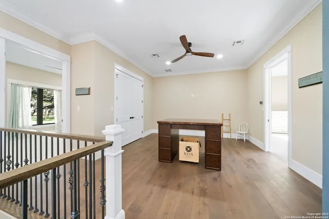 a view of a big room with wooden floor and windows