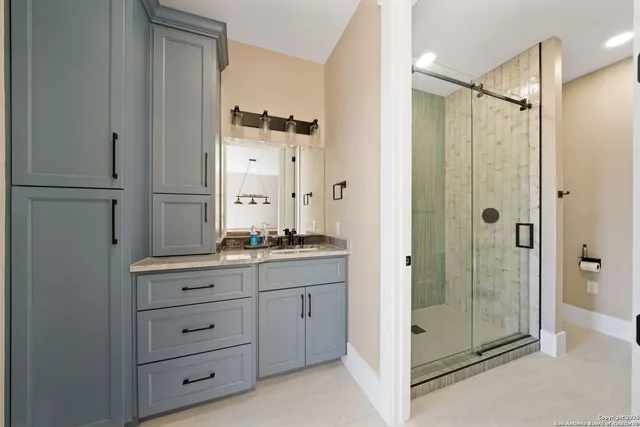 a bathroom with a shower sink and mirror