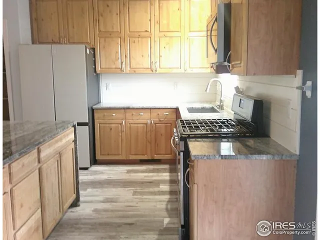 a kitchen with stainless steel appliances granite countertop a refrigerator sink and cabinets