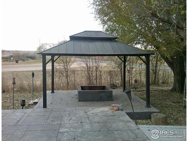 a backyard of a house with sofas table and chairs