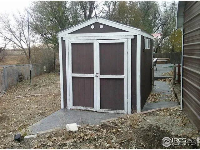 a view of a house with a door and wooden fence