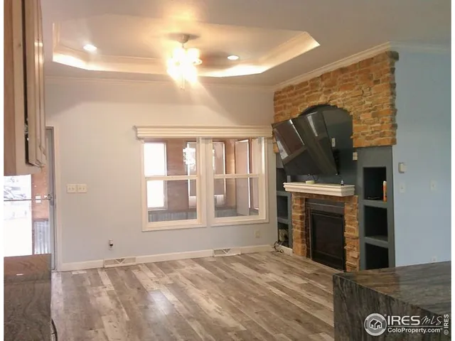a view of an empty room with a fireplace and a window