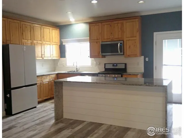 a kitchen with a refrigerator and a stove top oven