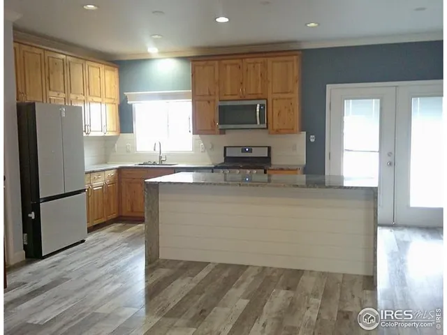 a kitchen with stainless steel appliances a refrigerator sink and microwave