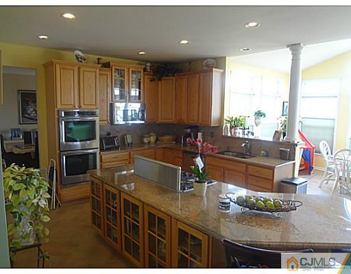 1 Sunflower Road Somerset, NJ 08873 - Photo 9 of 25 a kitchen with stainless steel appliances granite countertop a sink a stove and a refrigerator