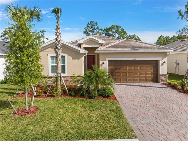 a front view of a house with a yard and potted plants