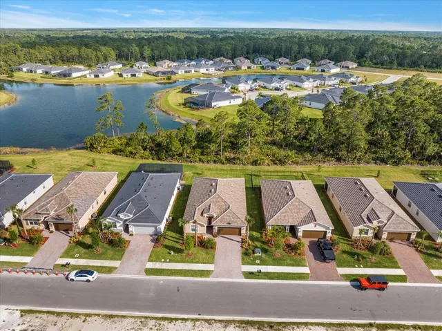 an aerial view of residential houses with outdoor space and lake view