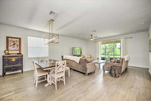 a living room with furniture chandelier and wooden floor