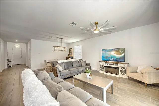 a living room with furniture and a flat screen tv with kitchen view
