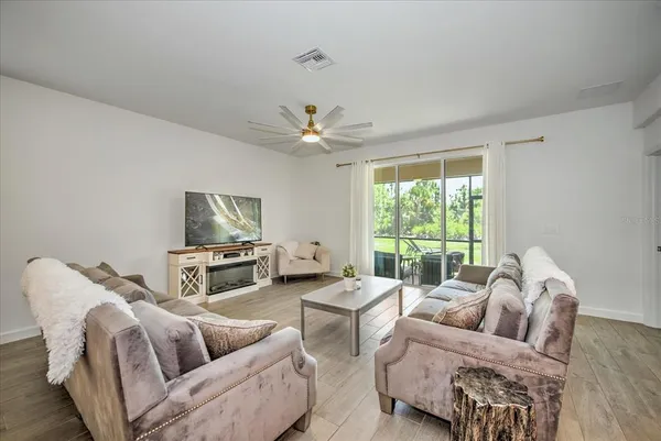 a living room with furniture a large window and a flat screen tv