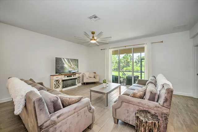 a living room with furniture a large window and a flat screen tv