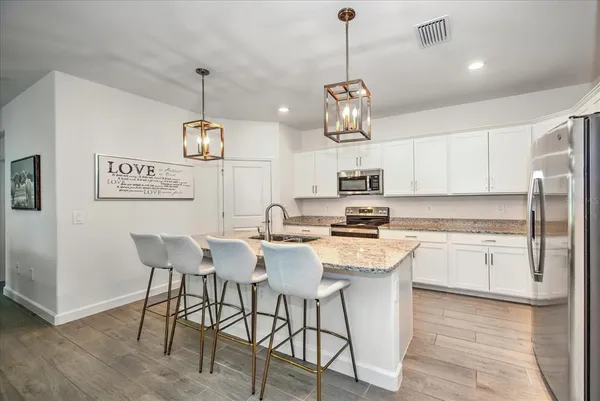 a kitchen with stainless steel appliances granite countertop a kitchen island a stove a table and chairs in it