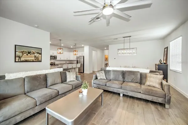 a living room with furniture and a view of kitchen