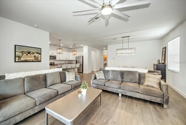 a living room with furniture and a view of kitchen