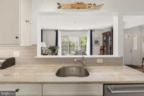 a view with granite countertop a sink and a window