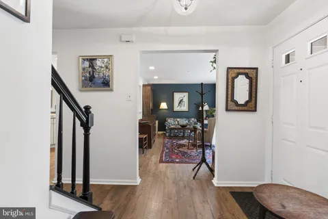 a view of a hallway with wooden floor and furniture