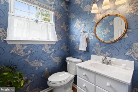 a bathroom with a granite countertop toilet sink and mirror