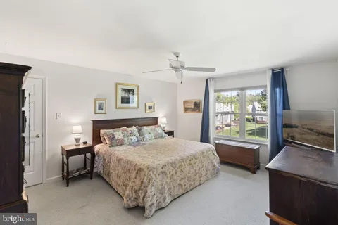 a bedroom with a bed and a dresser next to a window