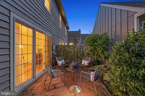 a view of a patio with table and chairs and potted plants with wooden floor and fence