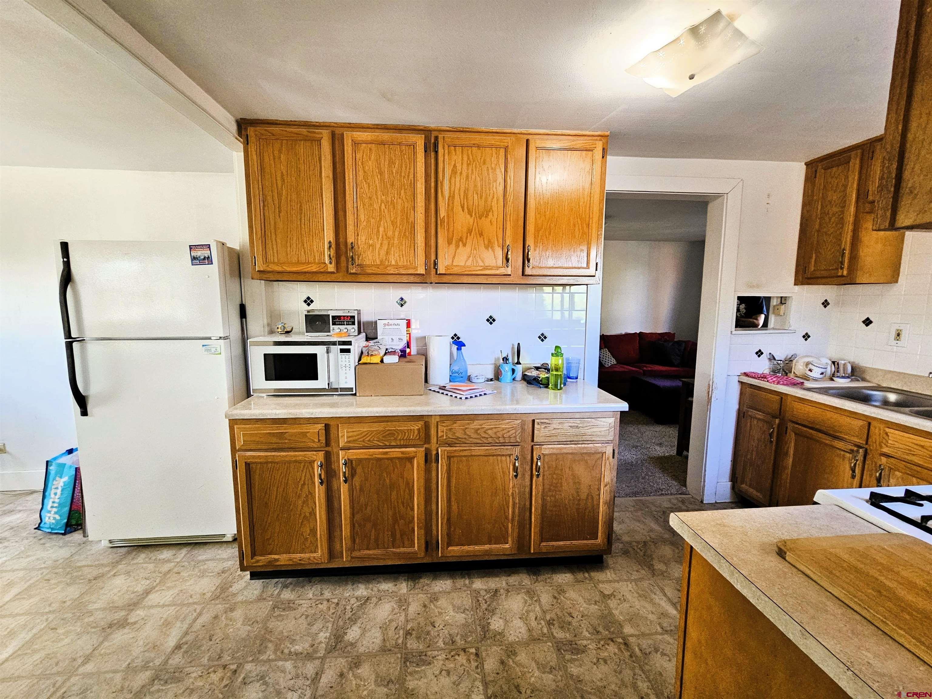 360 West 30th Street Durango, CO 81301 - Photo 11 of 30 a kitchen with stainless steel appliances a sink a stove a refrigerator cabinets and a window