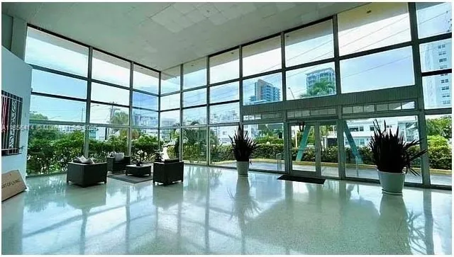 a lobby with a potted plant on the floor