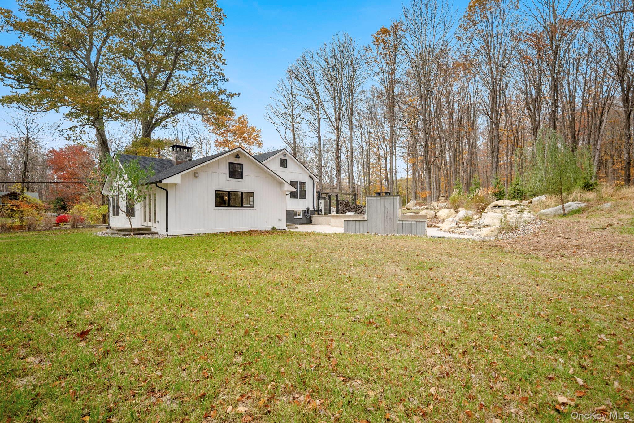379 South White Rock Road Holmes, NY 12531 - Photo 19 of 26 Rear view of house featuring a patio area, a chimney, and a lawn