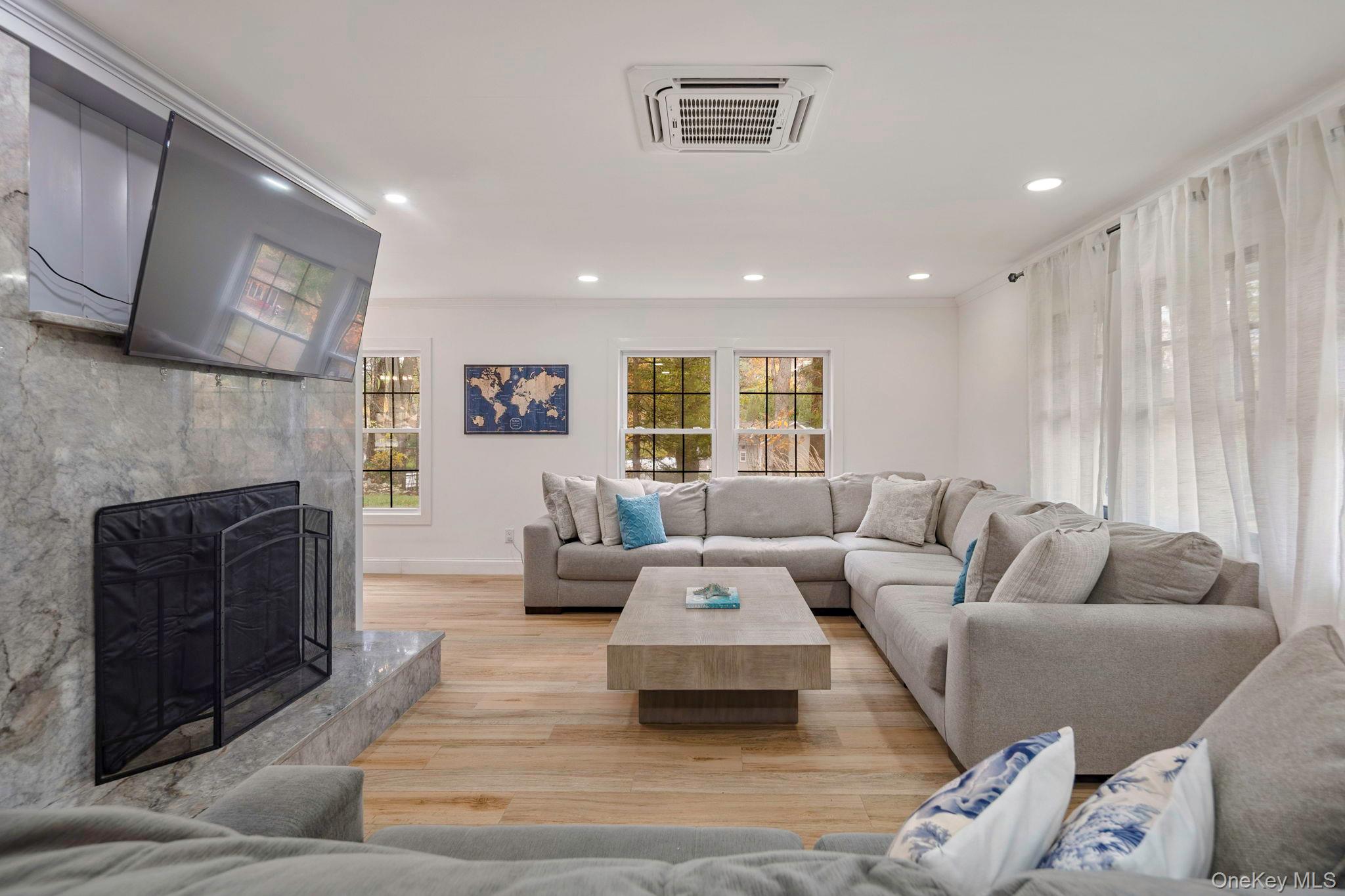 379 South White Rock Road Holmes, NY 12531 - Photo 3 of 26 Living area featuring light wood finished floors, a premium fireplace, recessed lighting, and ornamental molding