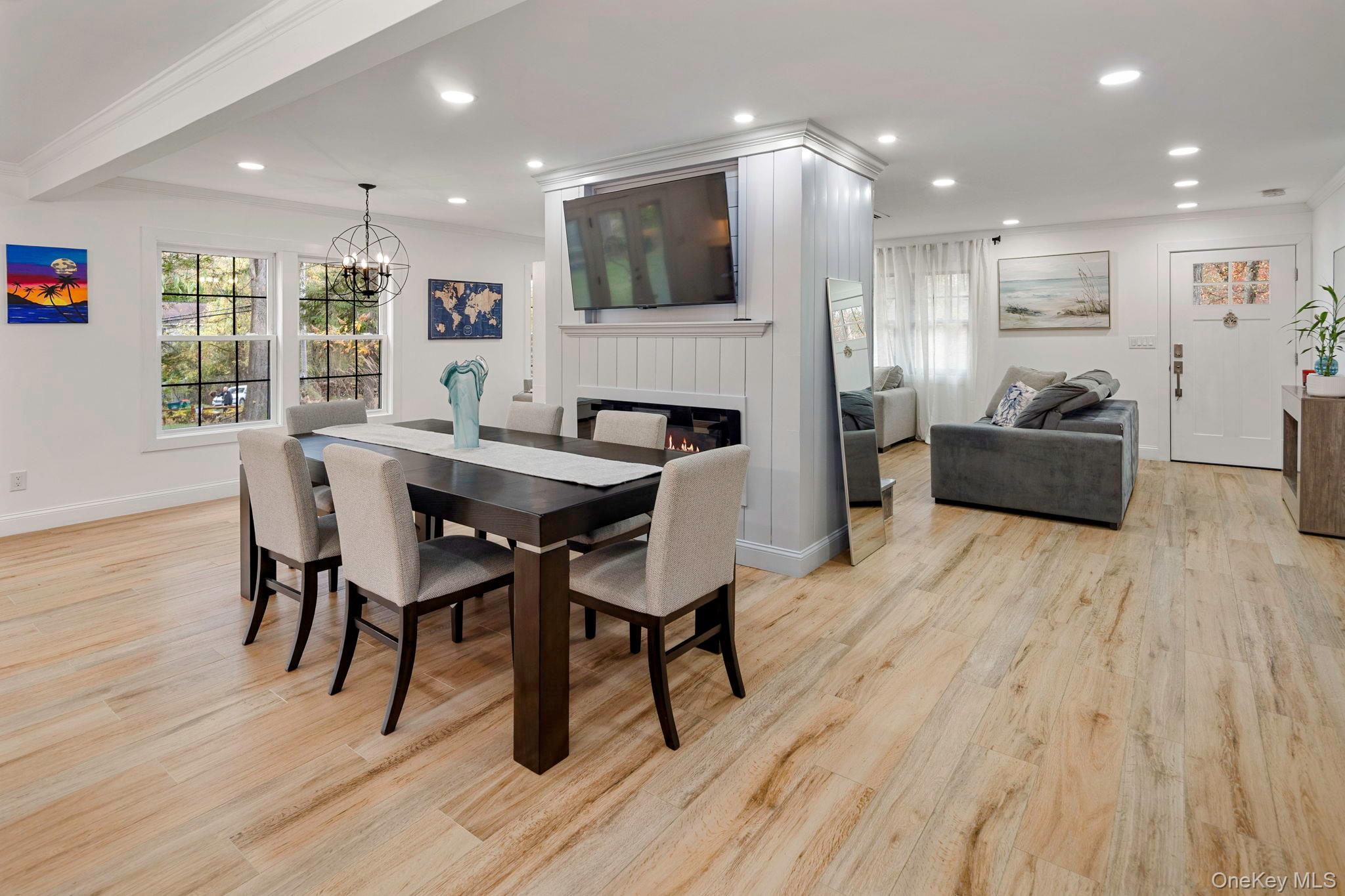 379 South White Rock Road Holmes, NY 12531 - Photo 4 of 26 Dining space with recessed lighting, crown molding, a glass covered fireplace, light wood finished floors, and a chandelier