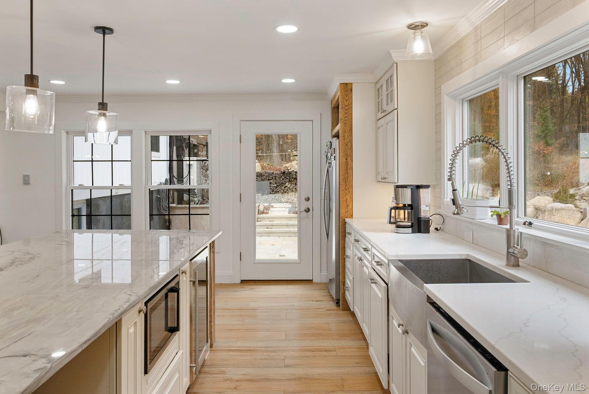 379 South White Rock Road Holmes, NY 12531 - Photo 8 of 26 Kitchen with light stone countertops, decorative light fixtures, ornamental molding, light wood-style floors, and plenty of natural light