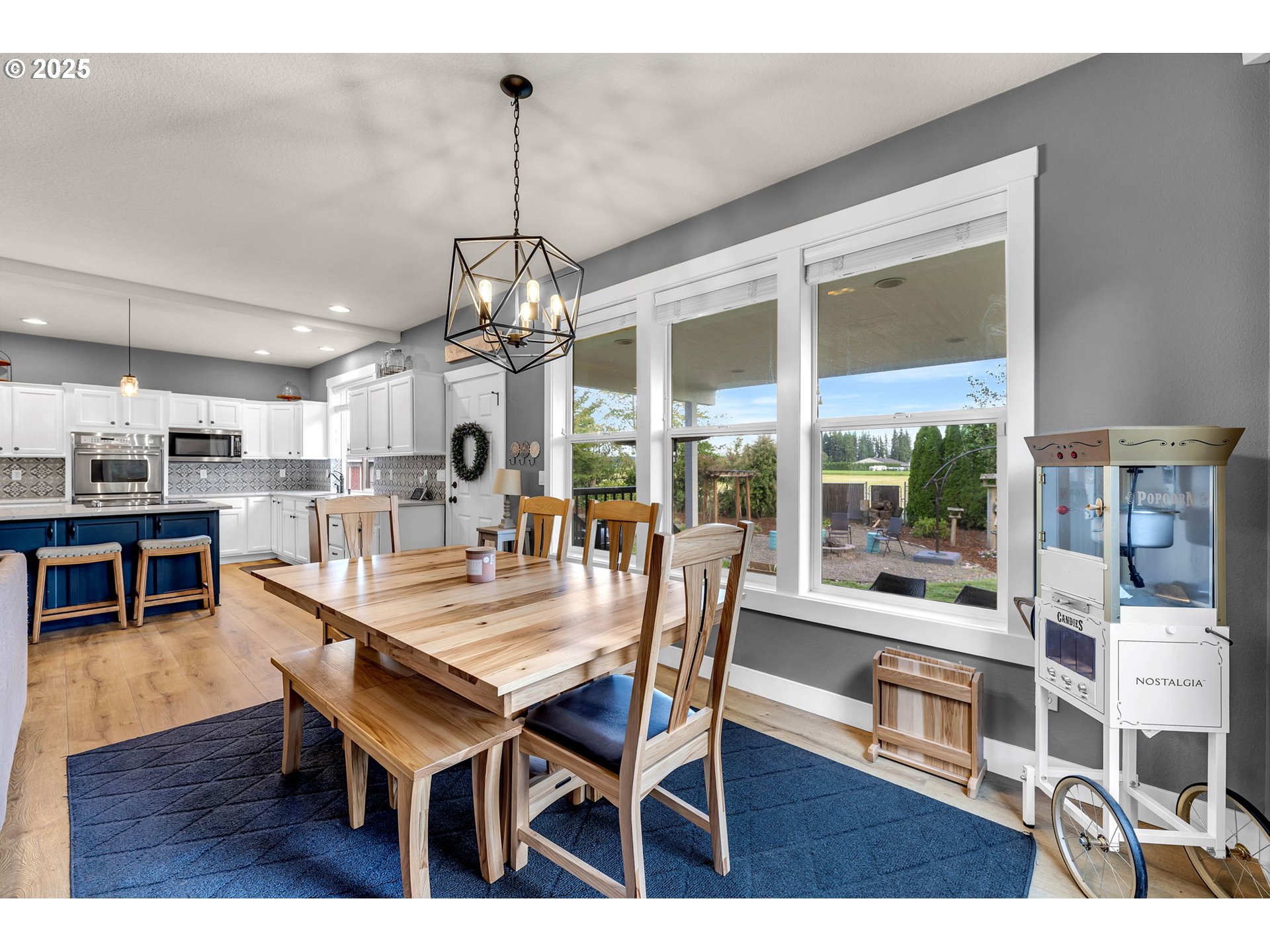 8805 Northeast 179th Street Battle Ground, WA 98604 - Photo 9 of 48 a dining room with wooden floor a chandelier a wooden table and chairs