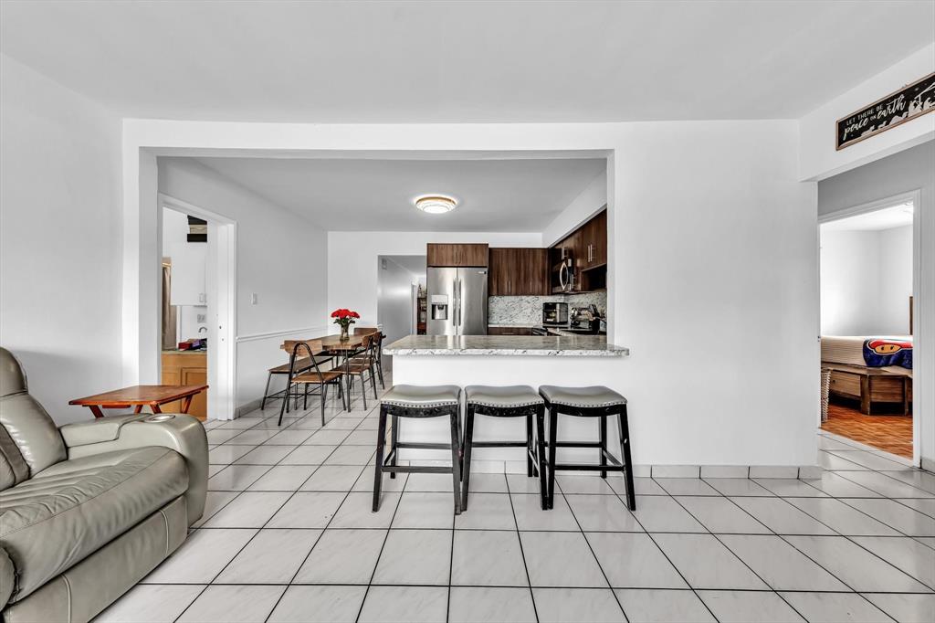 9311 Broad Manor Road Miami, FL 33147 - Photo 13 of 32 a living room with furniture a dining table and a stove top oven