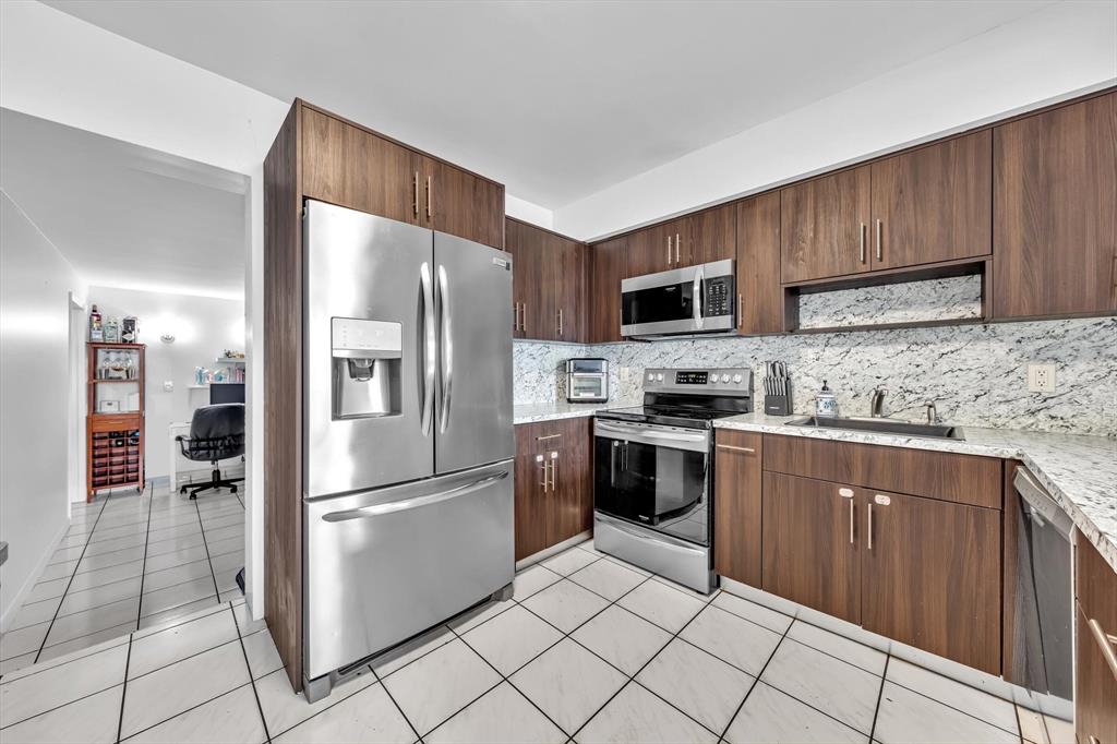 9311 Broad Manor Road Miami, FL 33147 - Photo 2 of 32 a kitchen with granite countertop a refrigerator and a sink