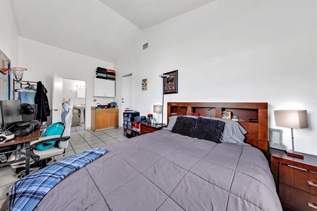 9311 Broad Manor Road Miami, FL 33147 - Photo 23 of 32 a bedroom with a bed a flat screen tv and dresser