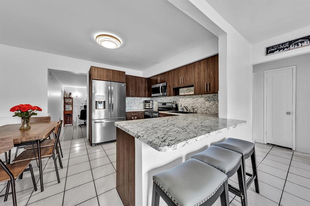 9311 Broad Manor Road Miami, FL 33147 - Photo 3 of 32 a kitchen with a table chairs refrigerator and microwave
