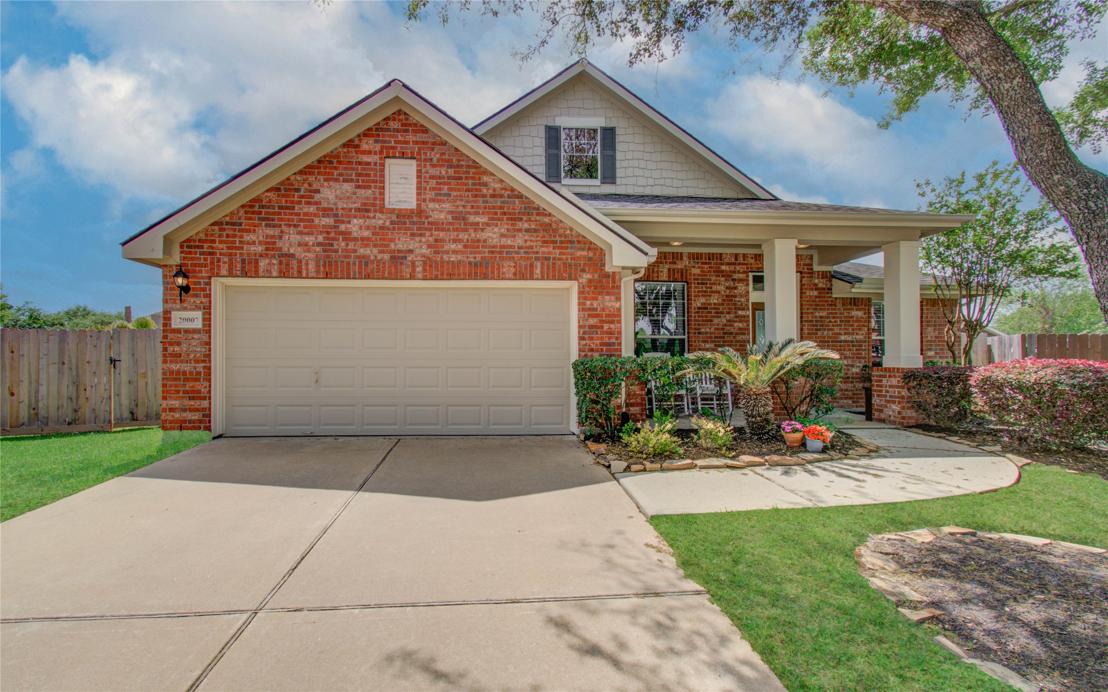 20007 Alcea Court Spring, TX 77379 - Photo 4 of 36 Charming brick home with a two-car garage and inviting front porch. Features a well-maintained lawn, mature trees, and tasteful landscaping, creating great curb appeal.