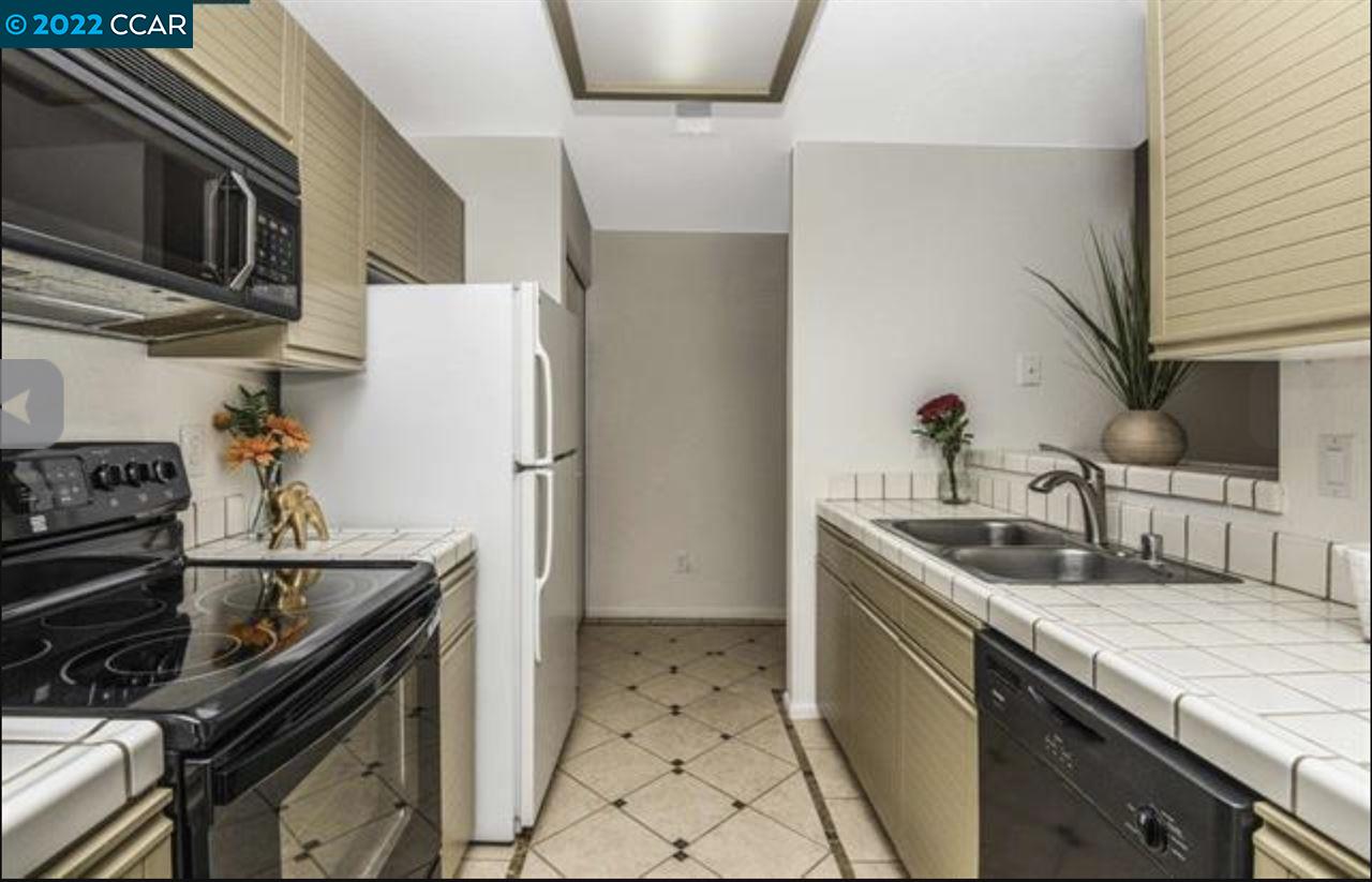 7650 Canyon Meadows Circle, Unit G Pleasanton, CA 94588 - Photo 11 of 24 a kitchen with stainless steel appliances granite countertop a sink stove and refrigerator