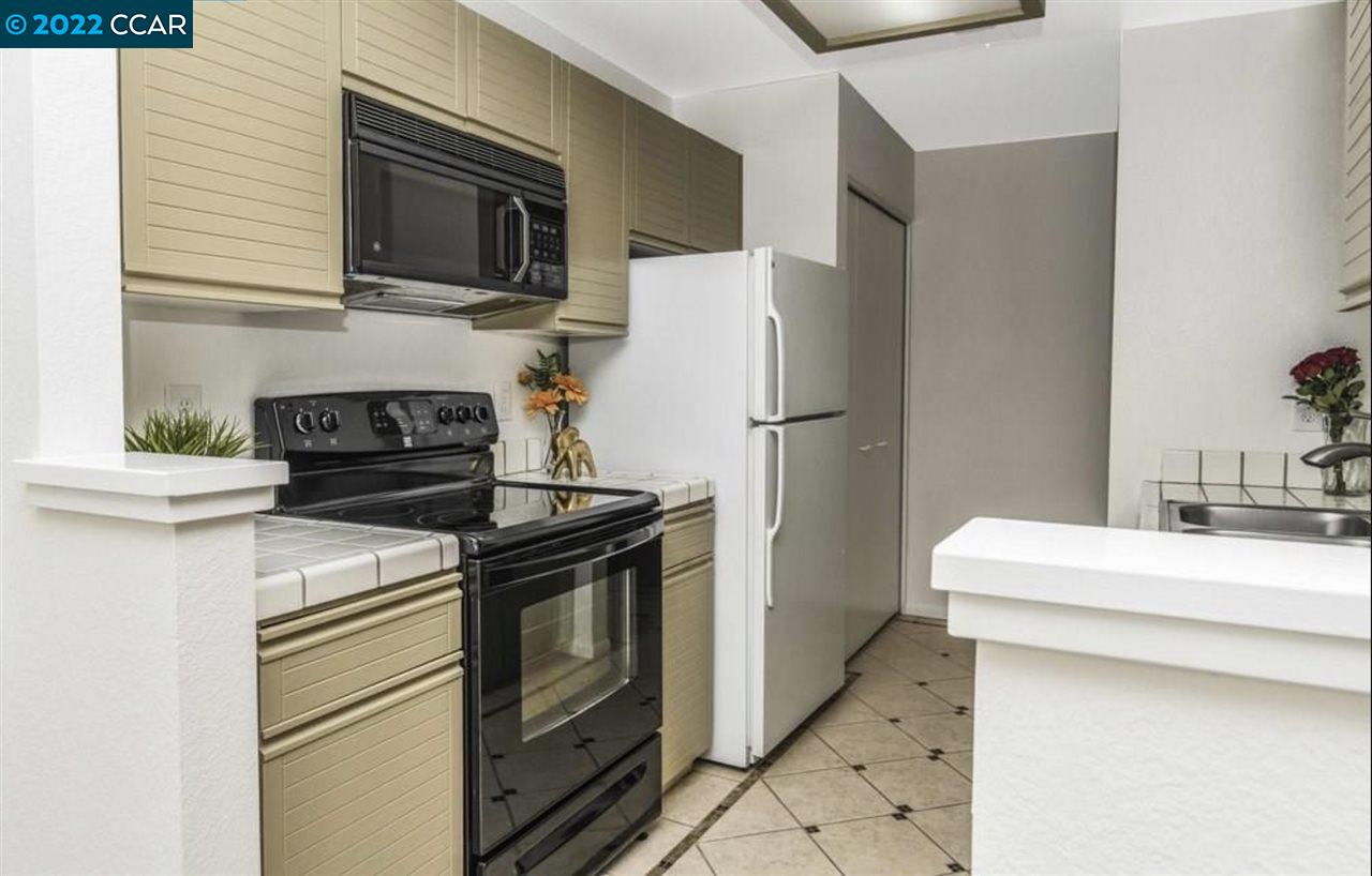 7650 Canyon Meadows Circle, Unit G Pleasanton, CA 94588 - Photo 12 of 24 a kitchen with a stove and a refrigerator