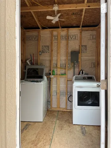 a utility room with a washing machine and a fireplace