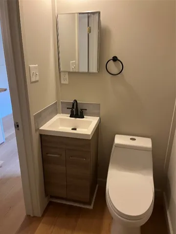 a view of a small space with wooden floor and a chandelier fan