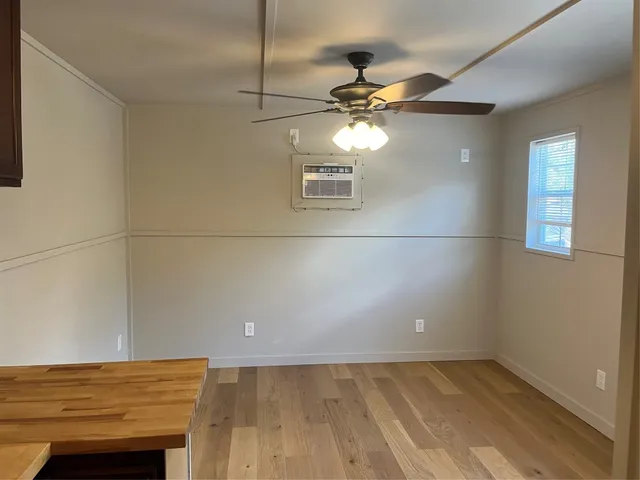 an empty room with a window and wooden floor