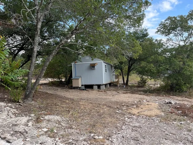a view of a house with a backyard and tree