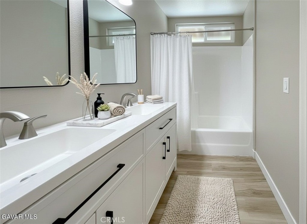 43856 Windsor Place Lancaster, CA 93536 - Photo 22 of 39 a bathroom with a sink a mirror and a bathtub