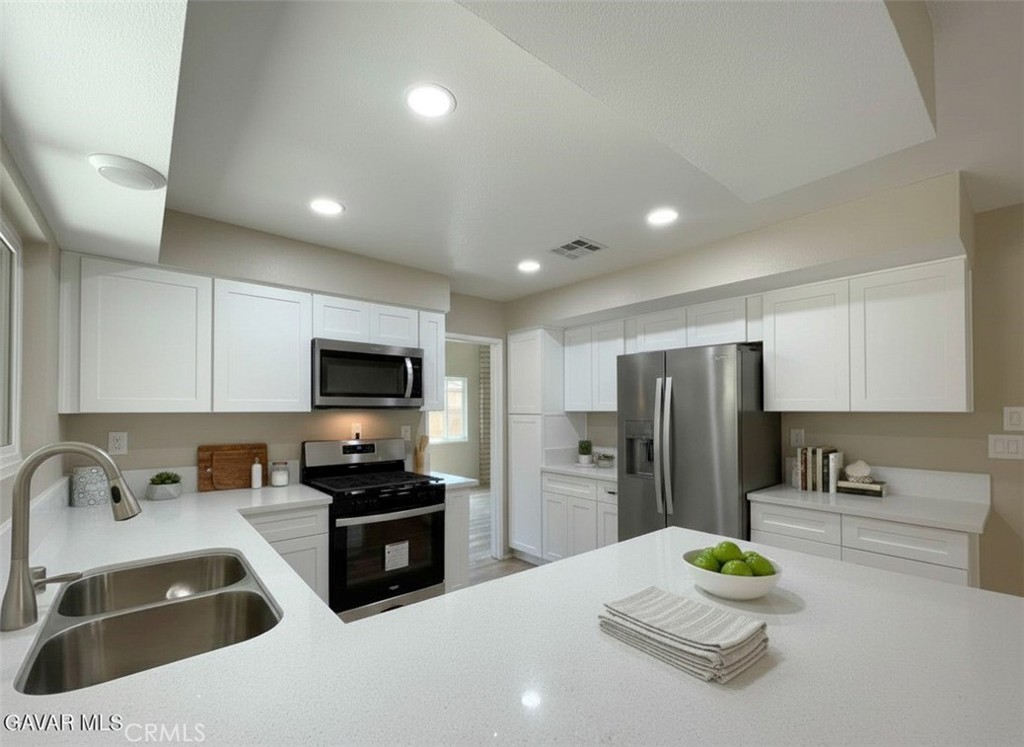 43856 Windsor Place Lancaster, CA 93536 - Photo 7 of 39 a kitchen with a sink a refrigerator a stove a microwave and cabinets