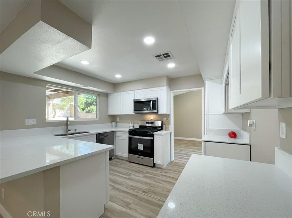 43856 Windsor Place Lancaster, CA 93536 - Photo 8 of 39 a large kitchen with stainless steel appliances granite countertop a refrigerator and a sink
