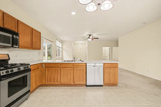 a kitchen with stainless steel appliances granite countertop a stove a sink and a microwave