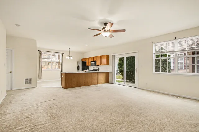 a view of a livingroom with a ceiling fan and window