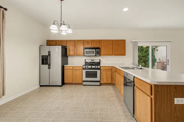 a kitchen with stainless steel appliances a stove a sink and a refrigerator